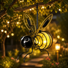 Solar bee lantern hanging in a garden at night