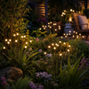 Solar LED firefly garden lamps glowing outdoors at night